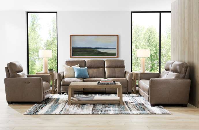 Living room with brown leather furniture, a rug, and a landscape painting.
