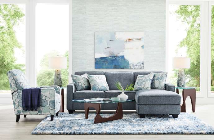 Living room with blue sofa, patterned chair, and rug.
