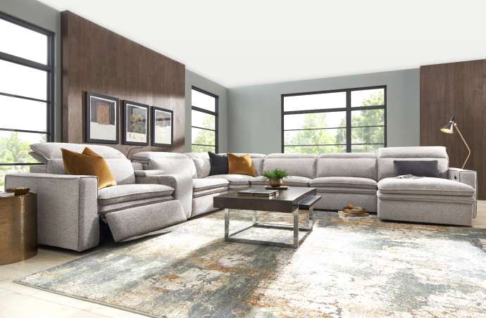 A sectional sofa in a living room with a rug and coffee table.
