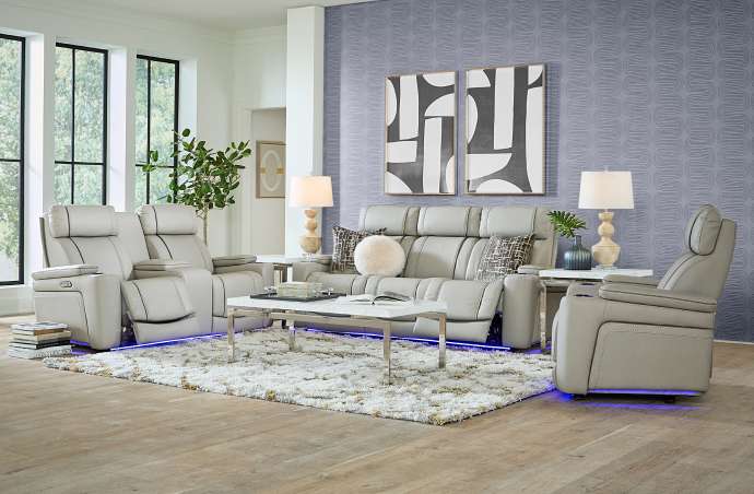 Living room furniture set with a light gray sofa and recliners, a white coffee table, and a fluffy rug.

