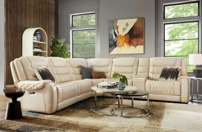 Cream-colored sectional sofa in a living room with a rug and coffee tables.
