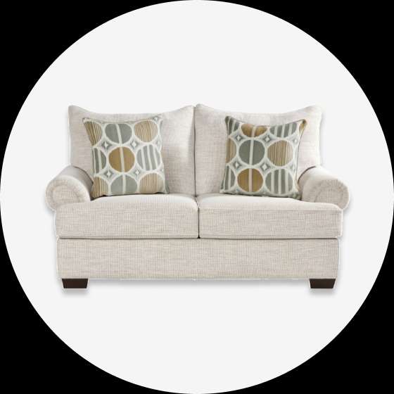 Cream-colored loveseat with two decorative pillows.
