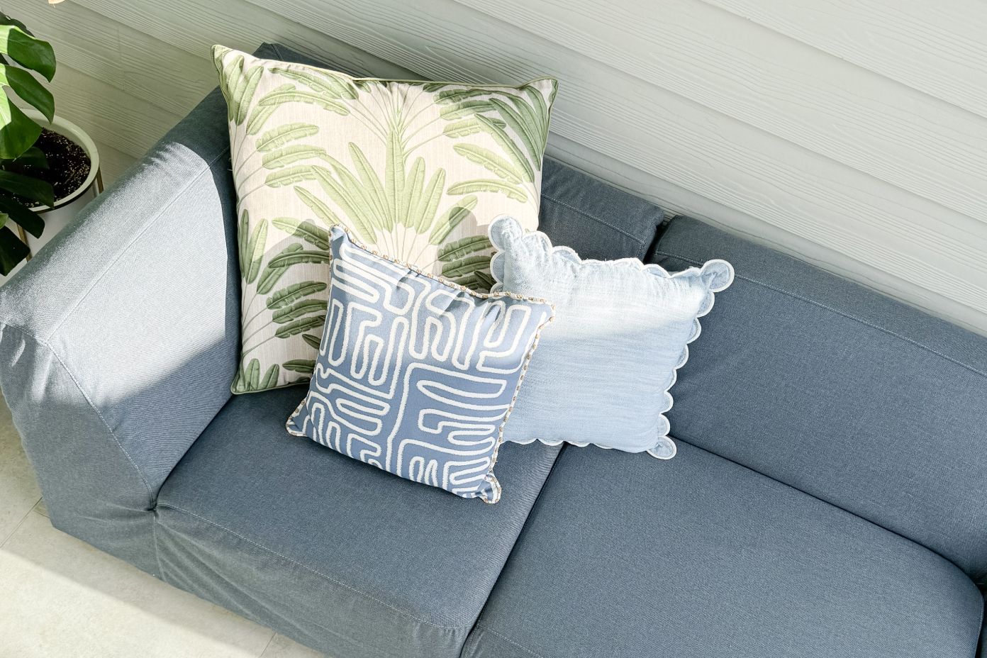 blue couch with light yellow pillows 