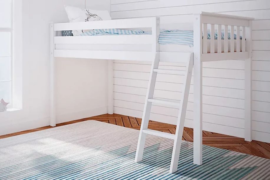 White loft bed with a ladder, on a wooden floor, with a striped rug.
