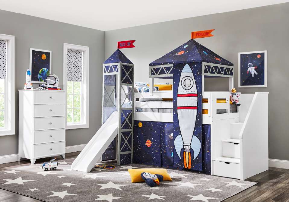 A child's bedroom with a rocket ship-themed bunk bed, a slide, and a star-patterned rug.
