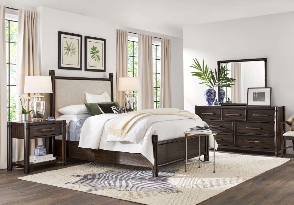Bedroom furniture set with a bed, nightstands, dresser, and rug.