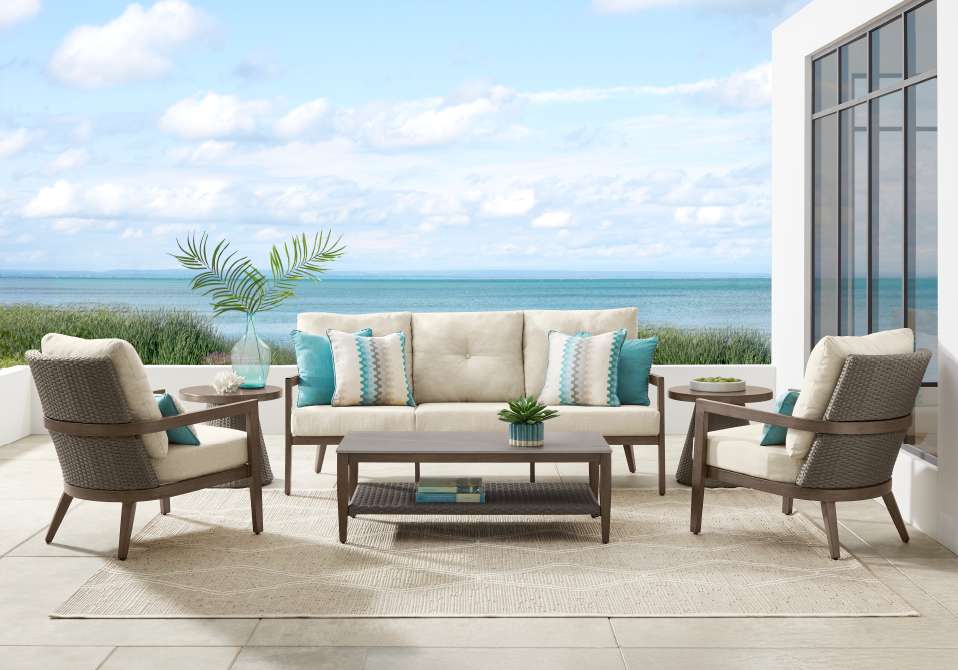 Outdoor patio furniture set with a sofa, two chairs, and a coffee table.
