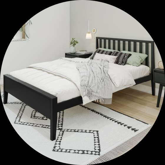 Black bed frame with a white comforter and patterned rug.
