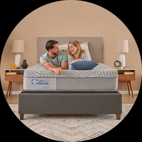 Sealy Posturepedic Hybrid mattress with a couple lying on it.
