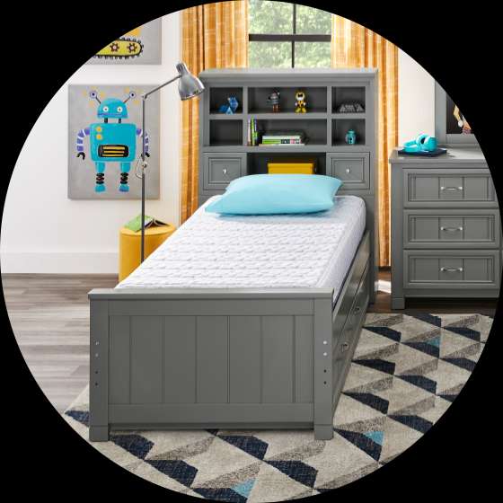 Gray bed with a headboard, a mattress, and a rug.
