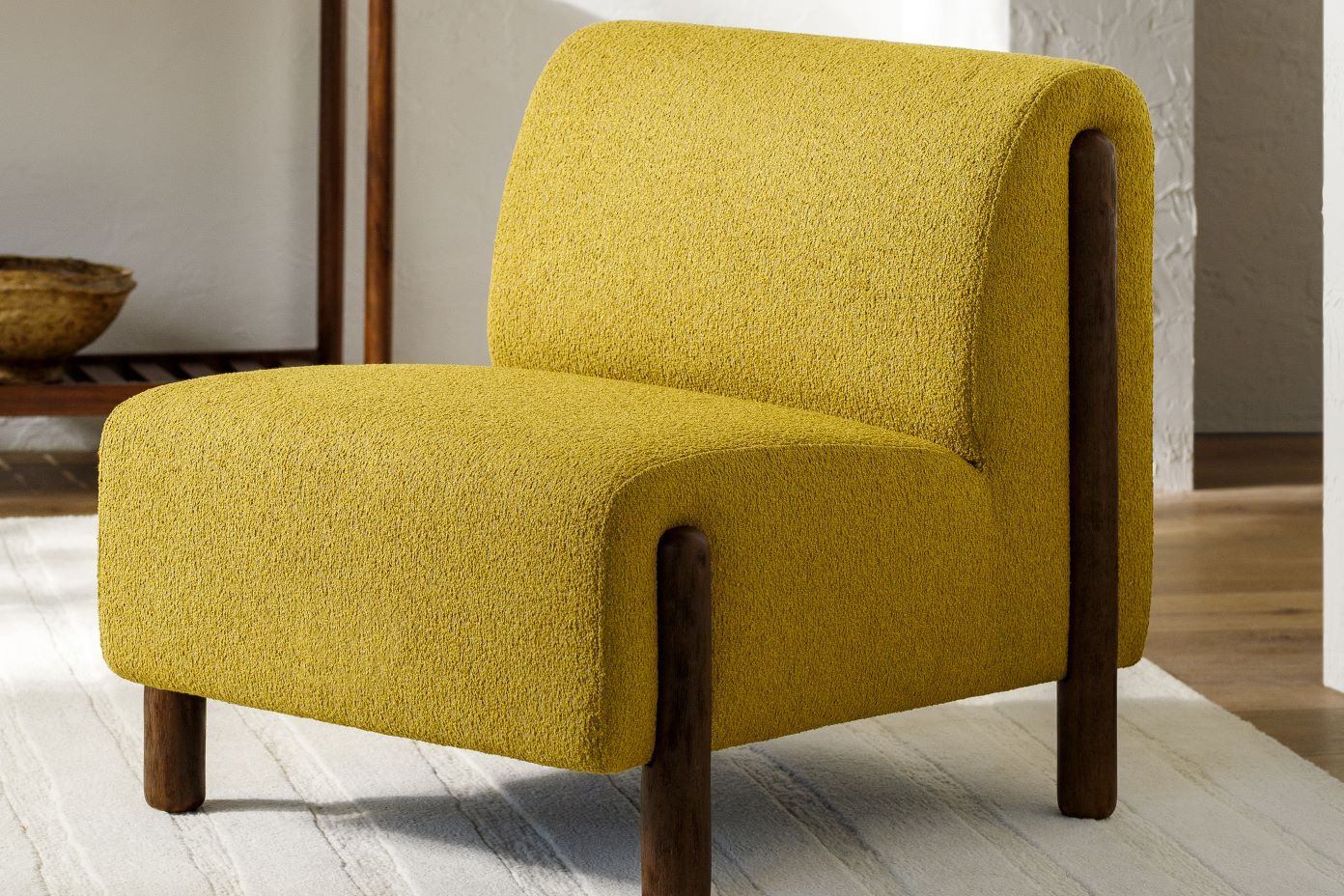Yellow upholstered armchair with dark wooden legs.
