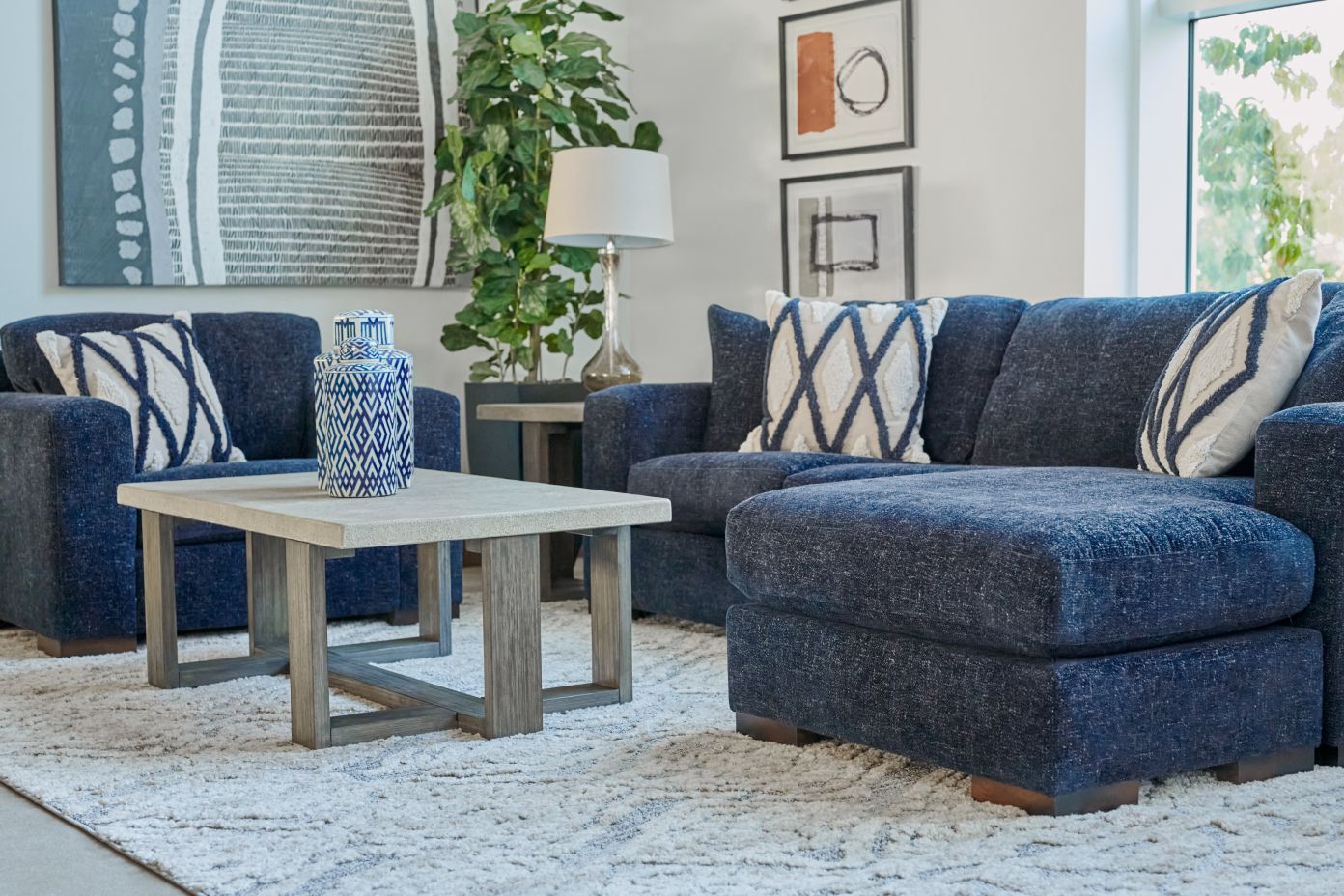 Living room with blue sofa, armchair, and coffee table.
