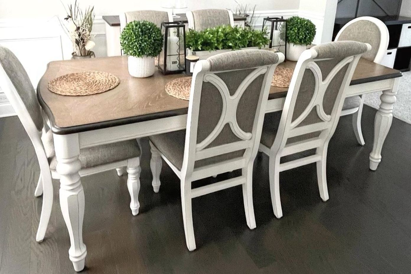 Dining table with white legs and gray upholstered chairs.
