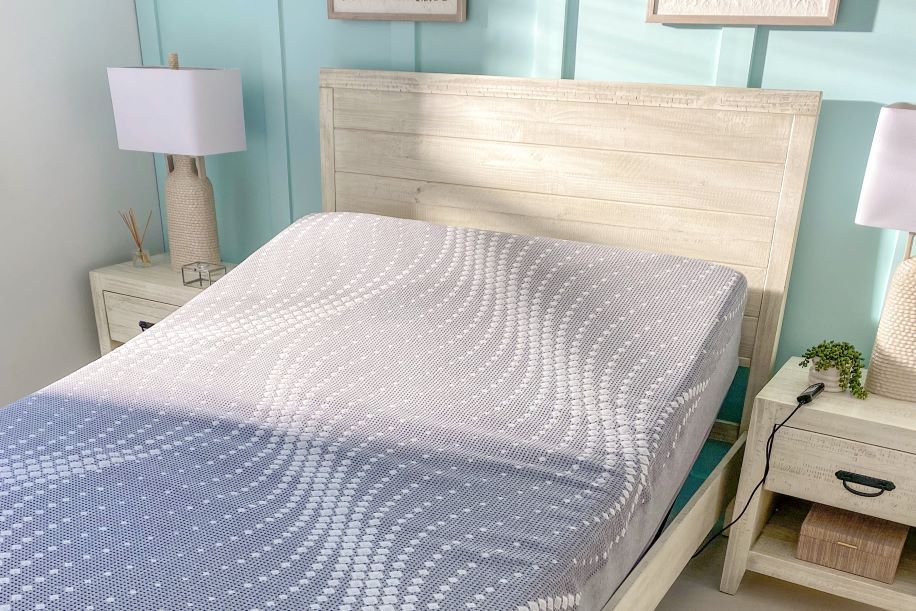 A bed with an adjustable mattress and a light-colored wooden headboard.
