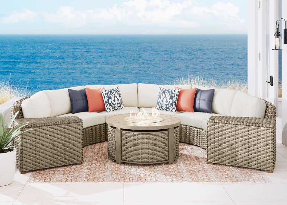 Outdoor sectional sofa with a fire pit table and storage ottomans.
