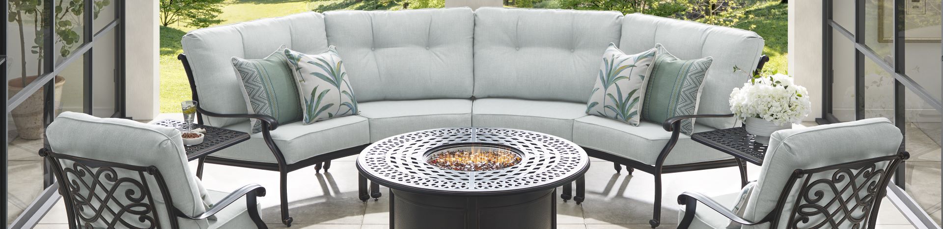 Outdoor sectional sofa with matching chairs and a fire pit table.