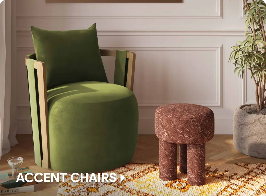 ACCENT CHAIRS. A green velvet armchair with wooden accents next to a textured brown stool on a patterned rug.