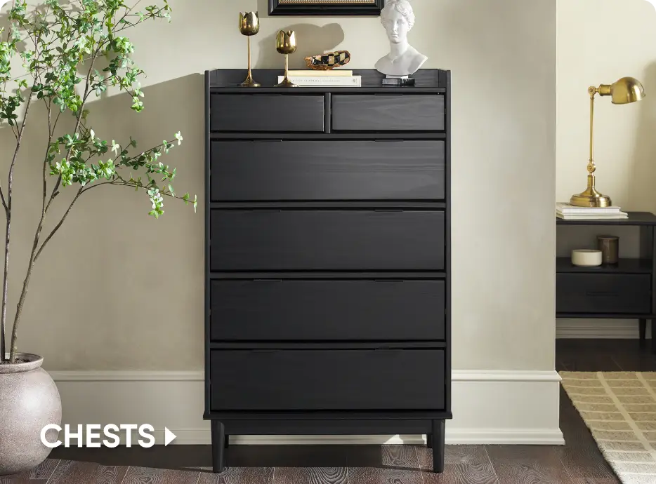 CHESTS. A tall, black wooden dresser with five drawers, styled with decorative items on top next to a potted plant.