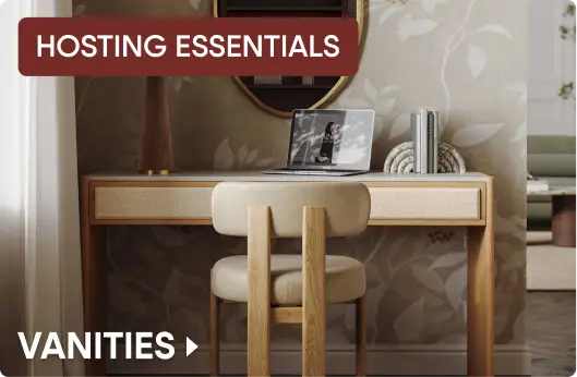 HOSTING ESSENTIALS VANITIES. A modern wooden vanity desk with a matching chair and a laptop in a stylish room.