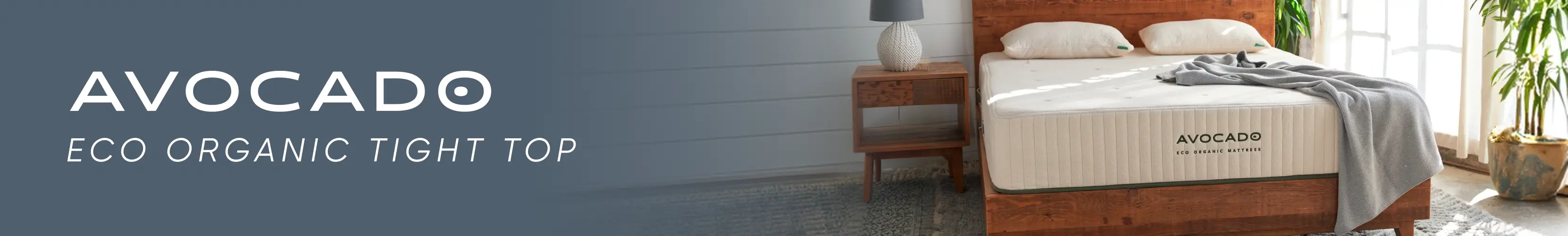 AVOCADO Eco Organic Tight Top mattress on a wooden bed frame in a bright, modern bedroom.