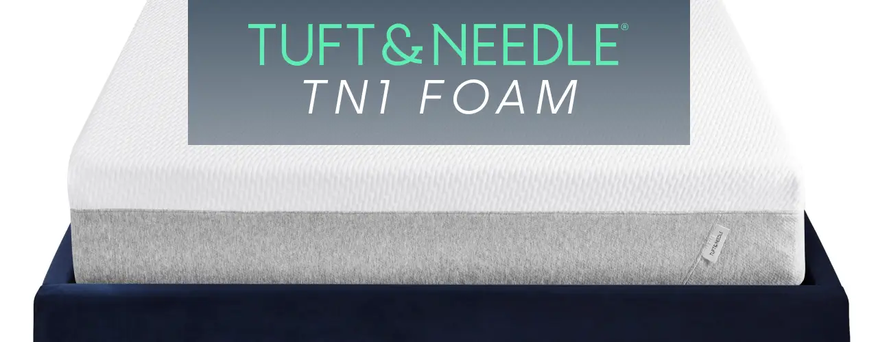 Tuft & Needle TN1 Foam mattress. A white and grey foam mattress sits on a dark blue bed frame.