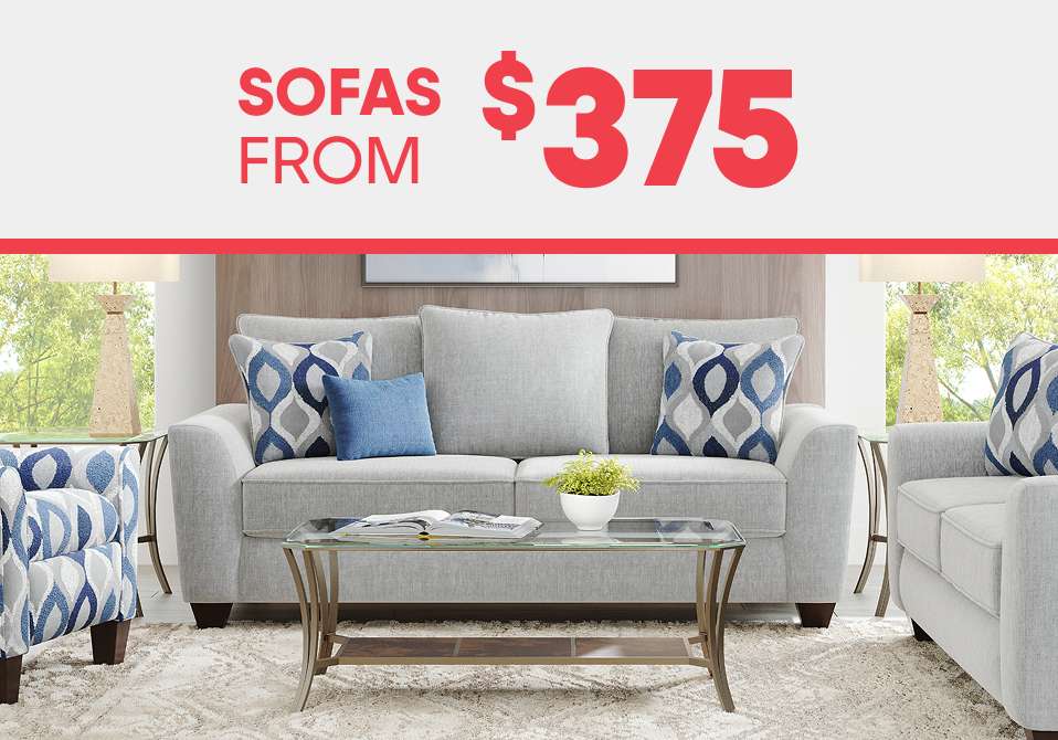 SOFAS FROM $375. A light gray sofa with patterned pillows and a glass coffee table.
