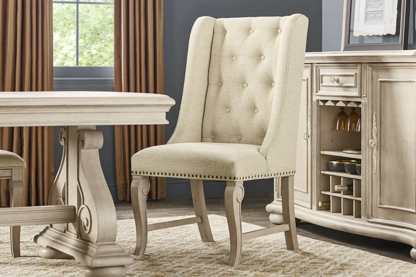 Beige upholstered dining chair with button tufting.

