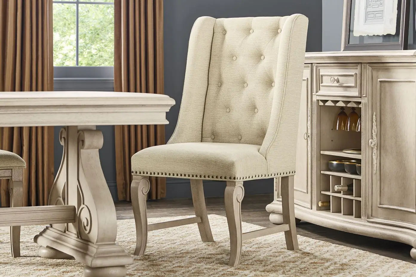 Beige upholstered dining chair with button tufting.
