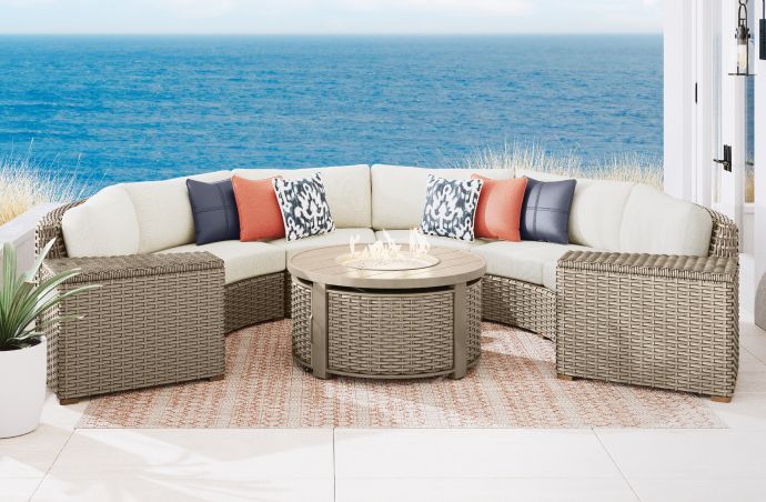 Outdoor sectional sofa with a fire pit table and storage ottomans.
