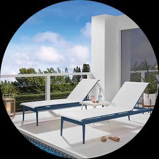 Two blue and white chaise lounge chairs on a deck.
