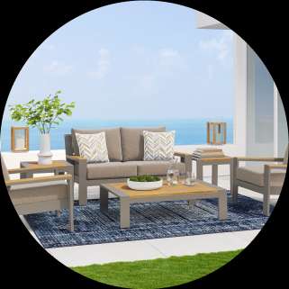 Outdoor furniture set on a patio overlooking the ocean.
