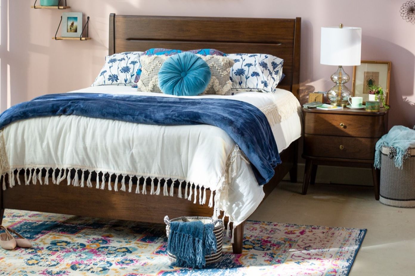 Bedroom with a wooden bed, nightstand, and colorful rug.
