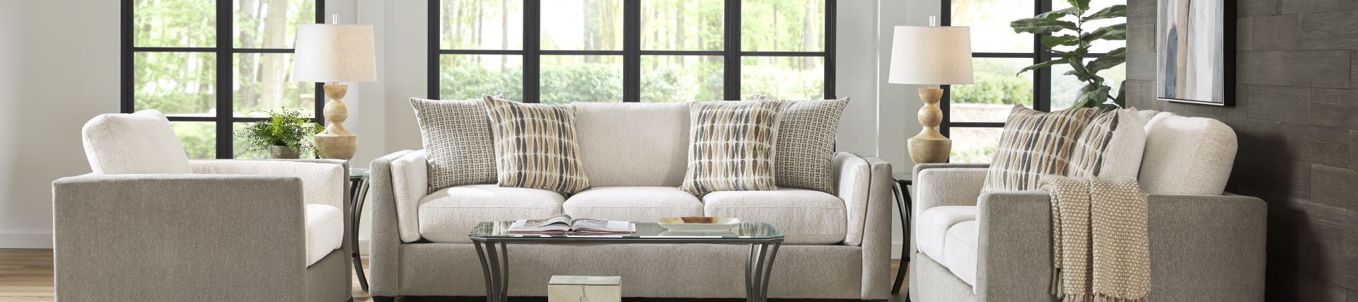 Living room furniture set with a sofa, two armchairs, and a glass coffee table.
