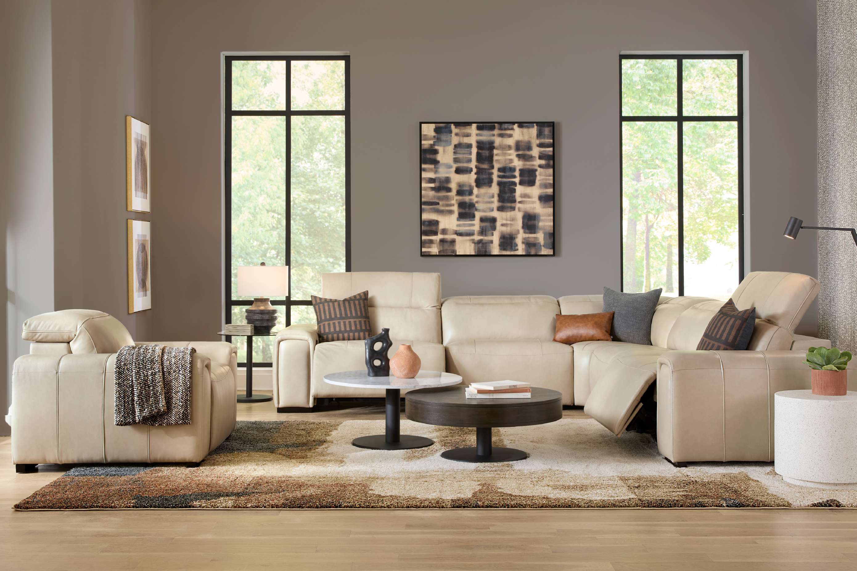 A beige sectional sofa with throw pillows, a rug, and two framed pictures.
