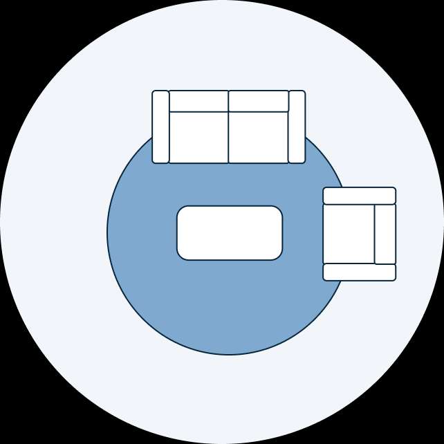 A top-down view of a living room layout with a sofa, coffee table, and armchair on a round rug.
