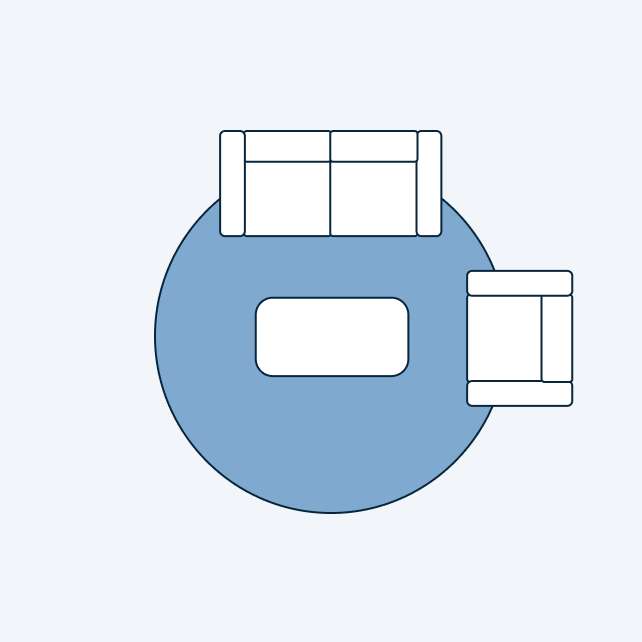 A top-down view of a living room layout with a sofa, coffee table, and armchair on a blue rug.
