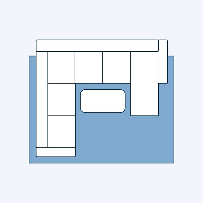 A top-down view of a sectional sofa and a coffee table on a blue rug.
