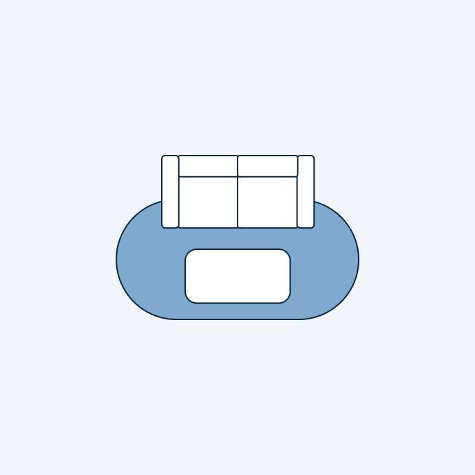 Top-down view of a sofa on a blue rug.
