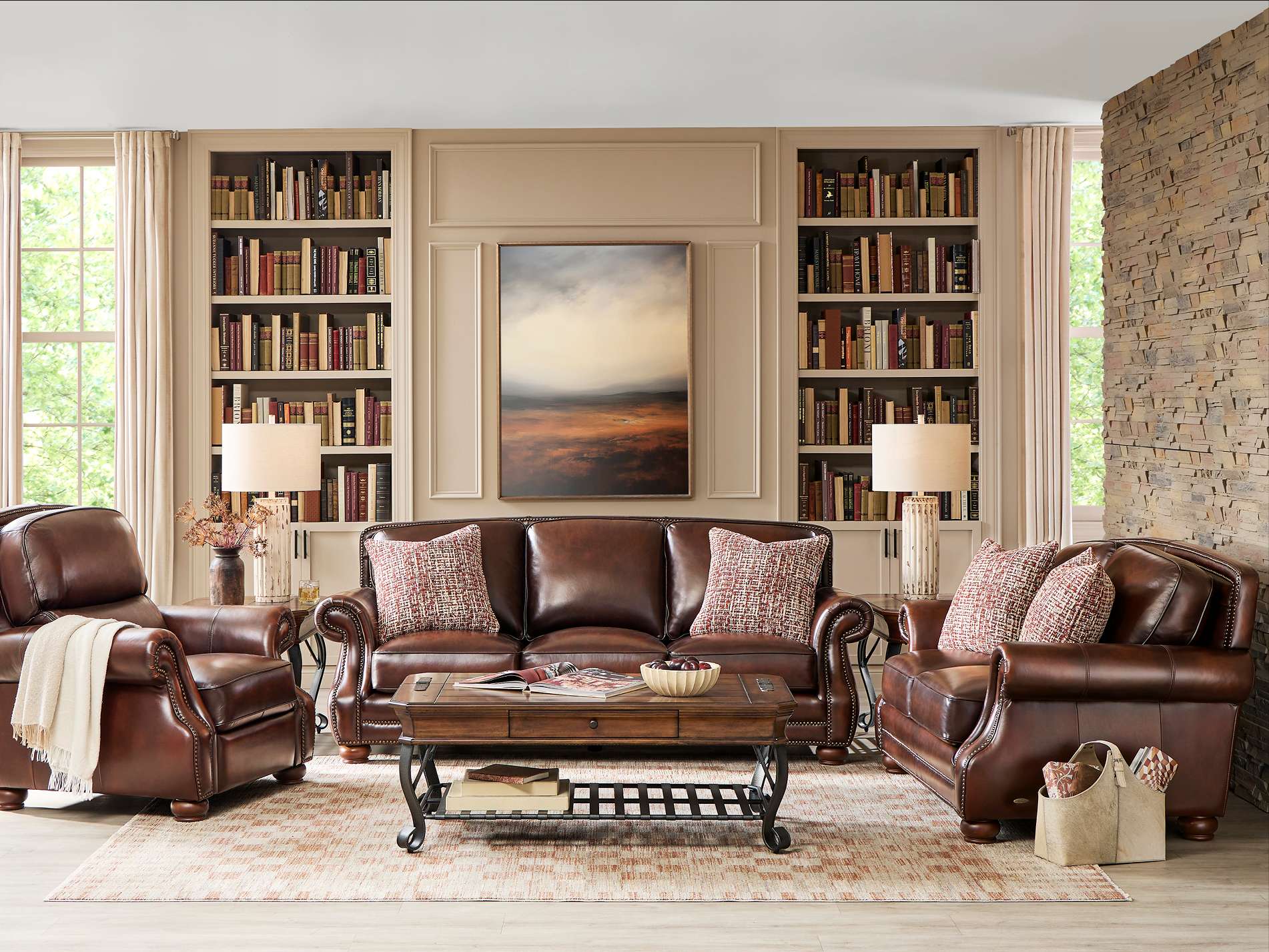 Living room with brown leather furniture, bookshelves, and a coffee table.
