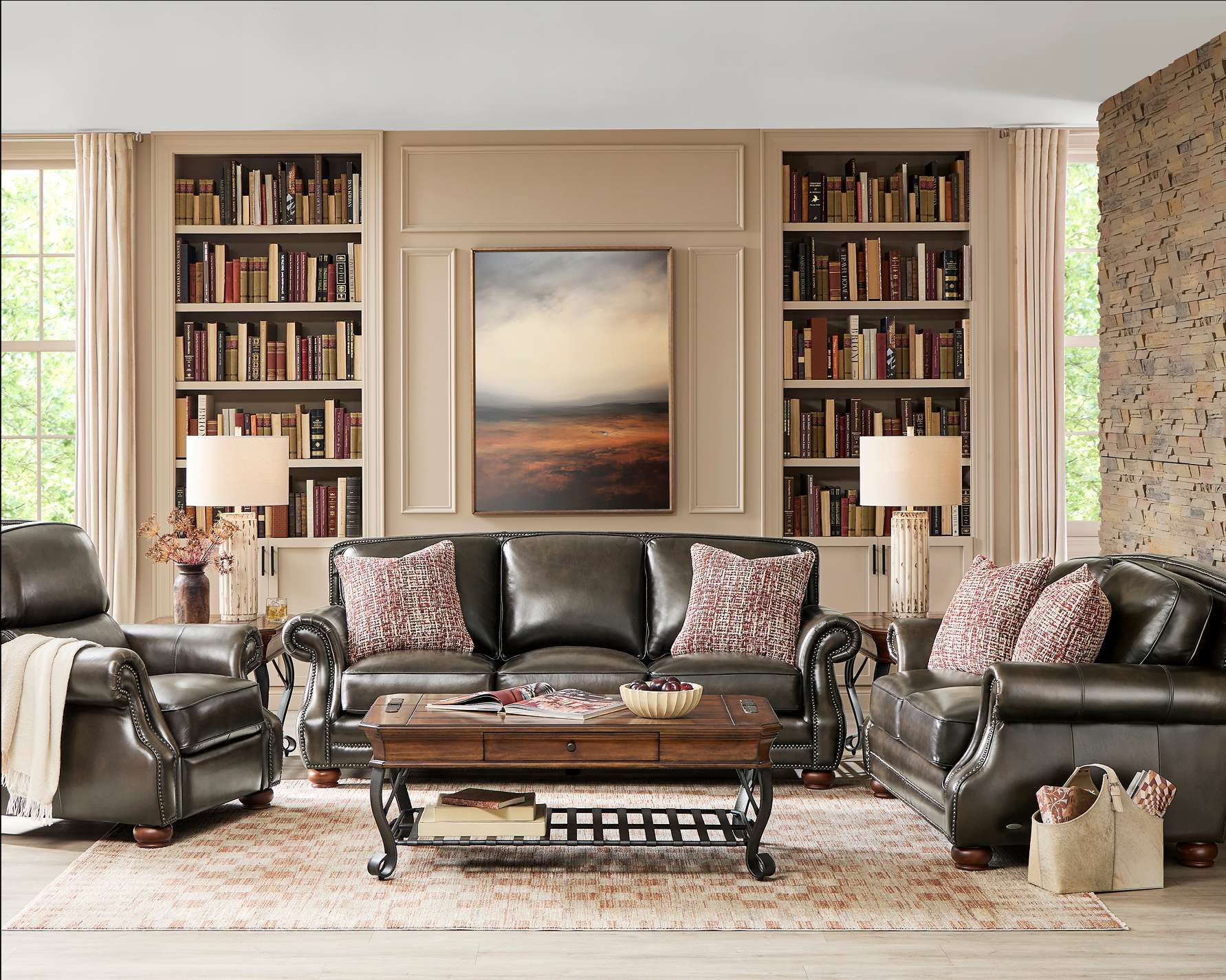 Living room with leather furniture, bookshelves, and a coffee table.
