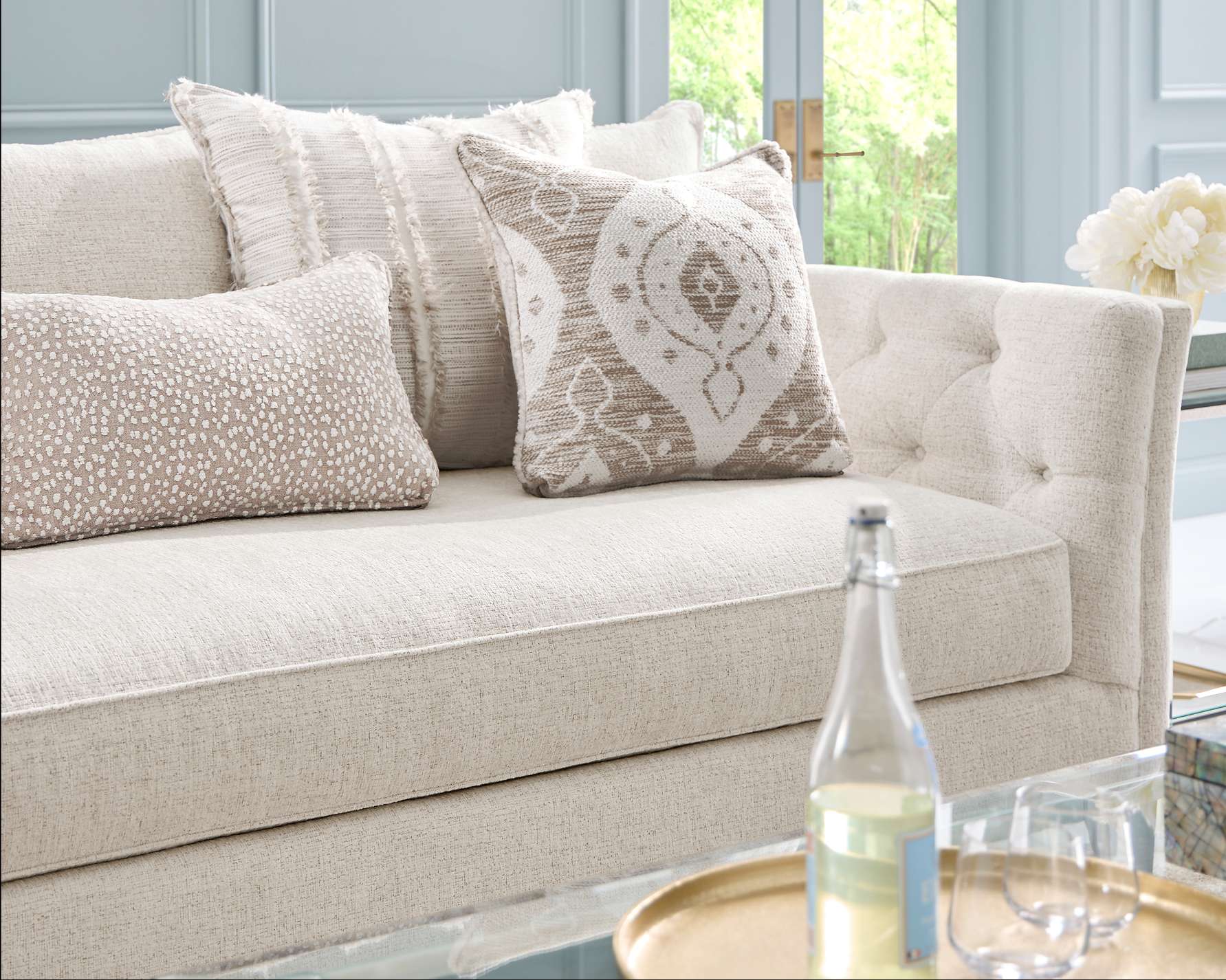 Cream-colored sofa with decorative pillows.
