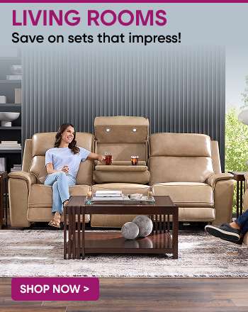 LIVING ROOMS. Save on sets that impress! A woman sits on a beige leather sofa with a coffee table in front of it.
