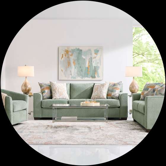 A living room set with a green sofa, two armchairs, and a coffee table.
