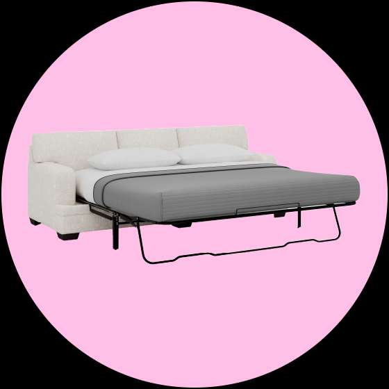 Sofa bed with a gray blanket and white pillows.

