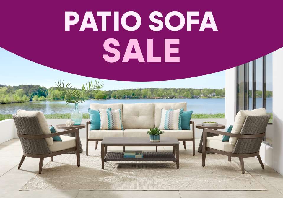 PATIO SOFA SALE. Patio furniture set with a sofa, two chairs, and a coffee table, overlooking a lake.
