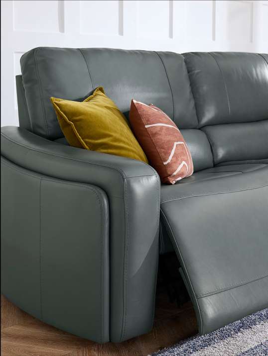 Gray leather reclining sofa with two pillows.
