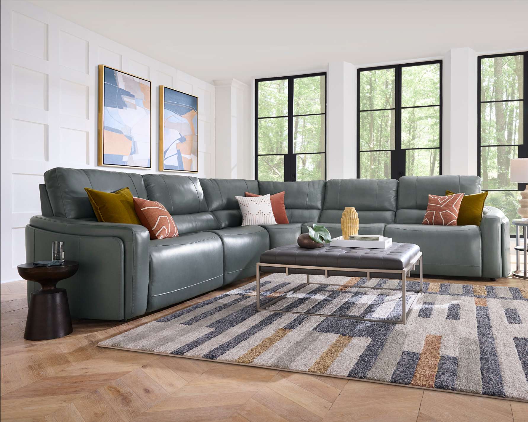 A sectional sofa in a living room with a rug and artwork.
