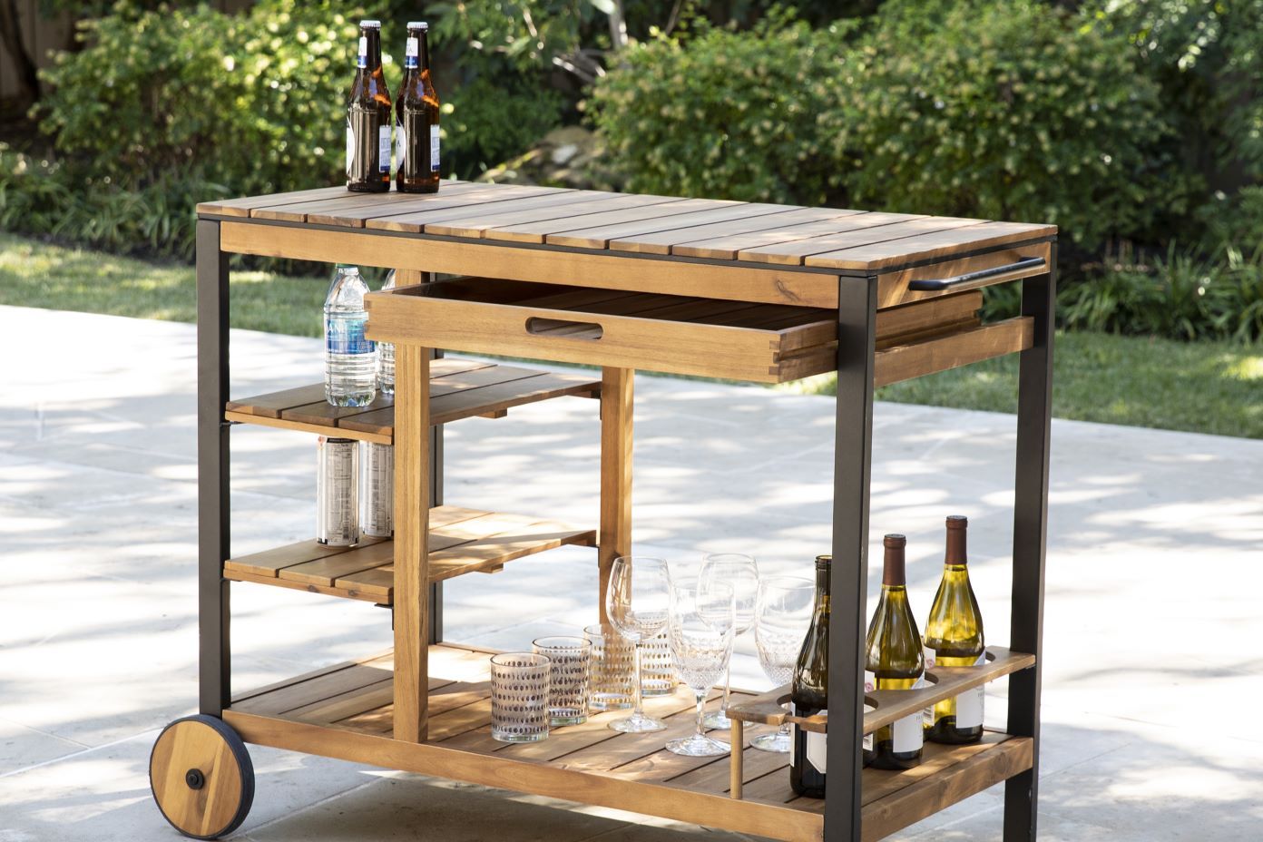 Wooden outdoor bar cart with shelves, a drawer, and wheels.
