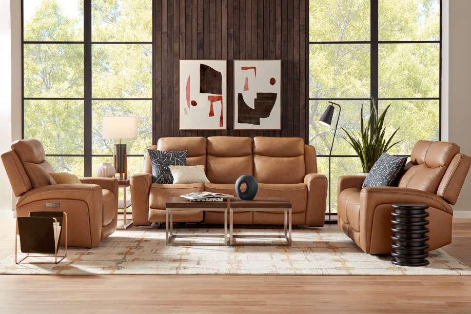 Living room with brown leather furniture, a rug, and large windows.
