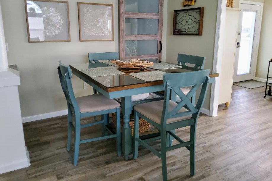A dining table with four blue chairs.
